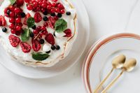 Kaboompics - Close Overhead Pavlova with Golden Spoons and Layered Ceramic Plates