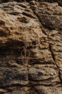 Kaboompics - Geometric Gold Earrings on a Natural Rock Wall