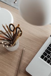 Kaboompics - Notebook, Silver Pen, Scissors and Pencil Cup beside a Laptop on a Wooden Desk