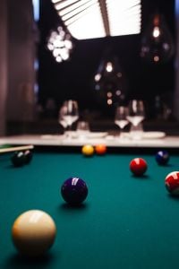 Billiard balls on green table with billiard cue