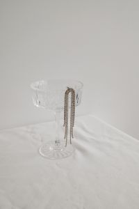 Kaboompics - Silver Chain Necklace on Crystal Glass – Fujifilm X100VI