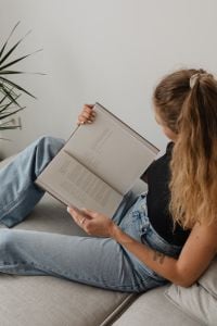 Kaboompics - Woman Holding an Open Book While Sitting on a Sofa