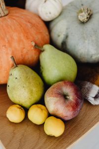 Kaboompics - Vertical Autumn Harvest Still Life with Orange Pumpkin, Green Pears and Red Apple on Plaid
