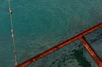 Kaboompics - Rusty Metal Railing over Teal Seawater