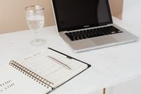 Kaboompics - Water Glass and Monthly Planner in a Marble Laptop Workspace