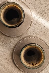 Kaboompics - Two Small Coffees on a Beige Stone Surface, Overhead Still Life