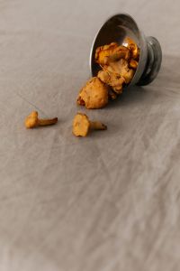 Kaboompics - Chanterelle Mushrooms Spilling from a Metal Bowl