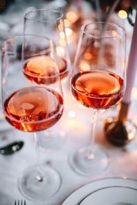 Rose Wine Glasses on an Elegant Christmas Table with Candlelight and Festive Decor