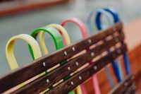 Kaboompics - Colorful Curved Bicycle Racks Seen through Weathered Wooden Bench Slats at Manufaktura