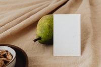 Kaboompics - Speckled Pear, Empty Business Card and Walnut Bowl on Beige Linen