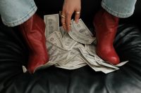Kaboompics - Red Leather Boots Standing on Dollar Bills Money Aesthetic