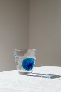 Kaboompics - Close-Up Water Glass with Blue Swirls and Soft Shadow, Beverage Photography