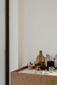 Kaboompics - Vertical Kitchen Counter Background with Pantry Jars, Cutting Boards and Utensil Crock, Blank Wall Copy Space