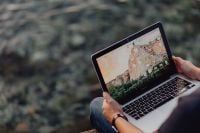 Kaboompics - A man using a Macbook laptop at the seaside
