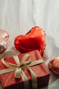 Kaboompics - Red Heart Balloon and Ribbon Tied Present on a Sheer Backdrop