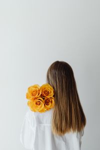Kaboompics - Woman Holding Orange Roses from Behind for Minimal Floral Portraits