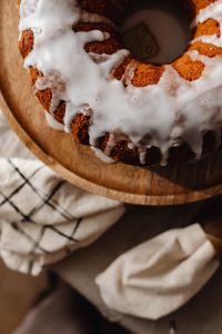 Kaboompics - Iced Bundt Cake on Wooden Cake Stand near Christmas Tree