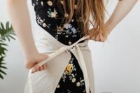 Kaboompics - Hands Tying a White Apron over a Floral Dress