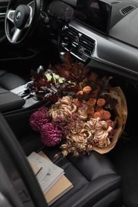 Kaboompics - Moody Autumn Bouquet and Notebooks in a Car