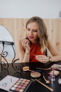 Kaboompics - Vertical Beauty Portrait of a Woman Applying Pink Lipstick Beside a Mirror
