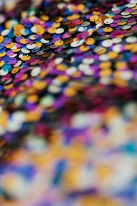Kaboompics - Multicolor Round Sequins on Dark Fabric, Diagonal Glitter Texture Background