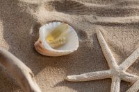 Kaboompics - Vitamin Capsules in a Shell on Sand with Starfish