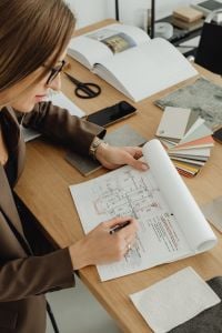 Kaboompics - Female Architect Drafting Floor Plan With Interior Finish Samples