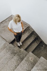 Kaboompics - Top-Down Portrait of Blonde Woman on Gray Stairs, Casual White Tee and Denim Outfit Inspiration