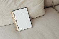 Kaboompics - Open Lined Notebook with Gold Spiral on a Beige Sofa