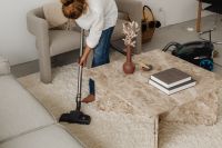 Kaboompics - Woman Vacuuming a Shaggy Rug Beside a Marble Coffee Table