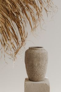 Kaboompics - A textured clay vase placed on a minimal stone pedestal - creating a natural - earthy aesthetic
