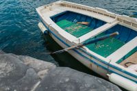 Kaboompics - Small White and Green Fishing Boat Moored by Naples Rocks