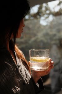 Kaboompics - Woman Sipping a Drink in Warm Natural Light