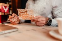 Kaboompics - Writing a Christmas Greeting Card at a Desk with Laptop and Gifts