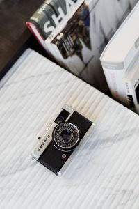 Kaboompics - Top-Down Olympus Trip 35 on Ribbed Marble with Vintage Photography Books