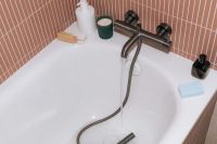 Kaboompics - Bathroom Bathtub with Black Faucet and Self Care Products
