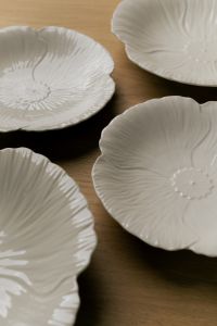Kaboompics - Vertical Arrangement of White Scalloped Ceramic Plates on Wood, Neutral Table Decor