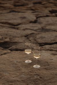 Kaboompics - Two White Wine Glasses on Malta's Warm-Toned Rocky Shore