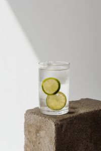 Kaboompics - Small Glass of Lime-Infused Water and Ice on a Stone Block with Bright Copy Space