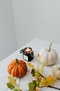 Kaboompics - Close-Up of Lit Black Candle Between Orange and White Pumpkins