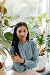 Kaboompics - Portrait of Asian Woman Standing Among Indoor Plants