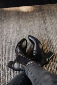 Kaboompics - Soft Focus Close-Up of Black Leather Ankle Boots on Textured Rug