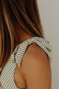 Kaboompics - Close-Up of Striped Halter Swimsuit Tie on a Sunlit Shoulder