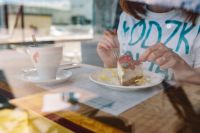 Kaboompics - Woman Enjoying Cheese Cake and a Coffee with Fruits in a Cafeteria