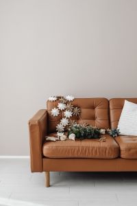 Kaboompics - Christmas Wreath and Paper Ornaments on Brown Leather Sofa