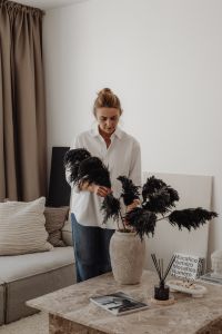 Kaboompics - Woman Arranging Black Dried Pampas Grass in a Living Room