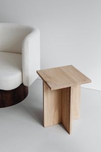Kaboompics - Light Bouclé Armchair Beside a Sculptural Oak Side Table