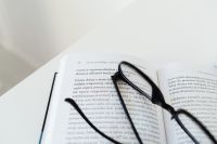 Kaboompics - Black Glasses Lying across Open Book Pages