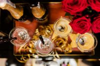 Kaboompics - Overhead New Year's Eve Champagne Toast with Red Roses and Gold Table Decor