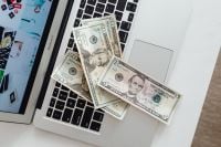 Kaboompics - US Dollar Bills on Laptop Keyboard, Money and Personal Finance Concept